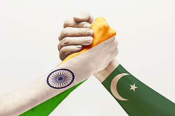 Image showing Two male hands competing in arm wrestling colored in Pakistan and India flags