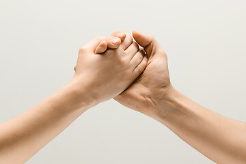 Image showing Two male hands competion in arm wrestling isolated on grey studio background