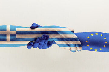 Image showing Male hands holding colored in blue EU and Greece flag