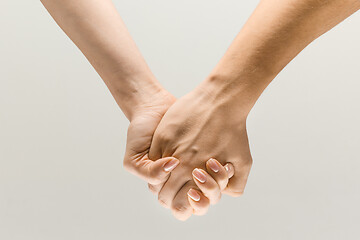 Image showing  loseup shot of human holding hands isolated on grey studio background.