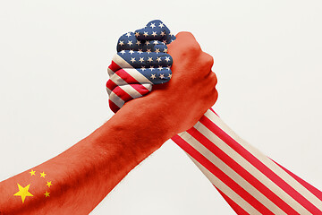 Image showing Two male hands competing in arm wrestling colored in China and America flags