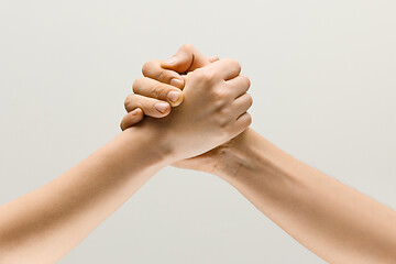 Image showing Two male hands competion in arm wrestling isolated on grey studio background