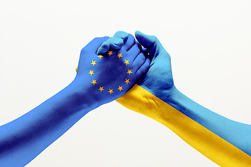 Image showing Two hands. Flag of the European Union. Flag of Ukraine.