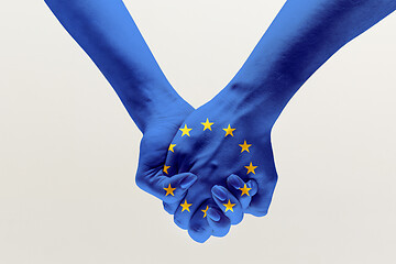 Image showing Human hands holding colored in blue EU flag