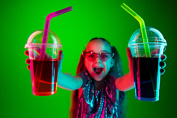 Image showing The happy teen girl standing and smiling against green lights background.