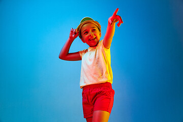 Image showing The happy teen girl standing and smiling against blue background.