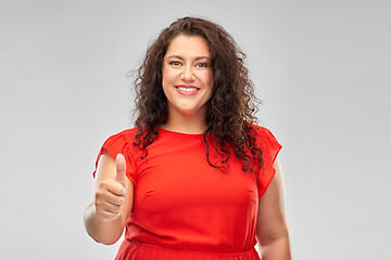 Image showing happy woman in red dress showing thumbs up