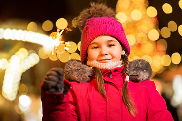 Image showing happy girl with sparkler at christmas market