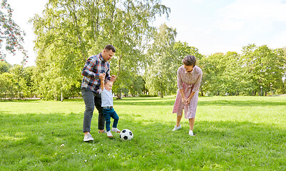 Image showing happy family playing soccer at summer park