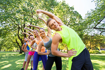 Image showing group of happy people exercising at summer park