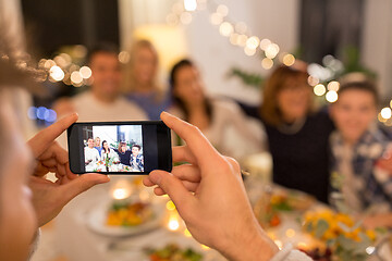 Image showing man taking picture of family at dinner party