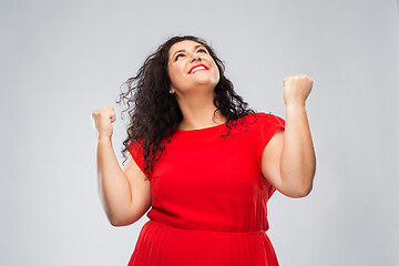 Image showing happy woman in red dress celebrating success