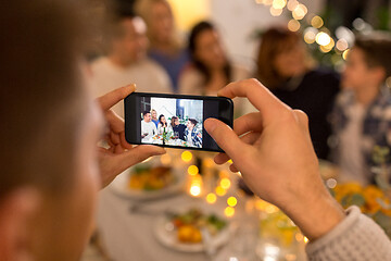 Image showing man taking picture of family at dinner party