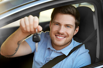 Image showing smiling man or driver with key sitting in car