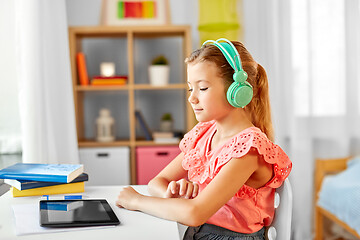 Image showing girl in headphones with tablet computer at home