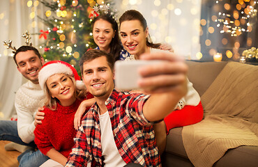 Image showing friends celebrating christmas and taking selfie