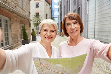 Image showing senior women with city map taking selfie outdoors