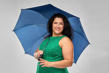 Image showing happy woman in green dress with blue umbrella