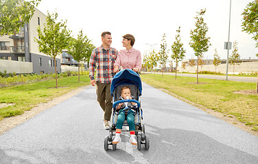 Image showing family with baby and stroller walking along city