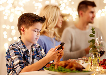 Image showing boy with smartphone at family dinner party