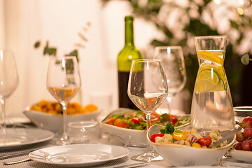 Image showing table served with plates, wine glasses and food