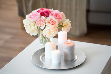 Image showing candles burning on table and flowers at cozy home