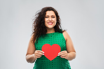 Image showing happy woman in green dress holding red heart