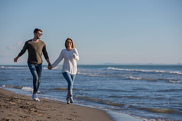 Image showing Loving young couple on a beach at autumn sunny day