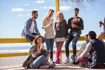 Image showing Group of friends having fun on autumn day at beach