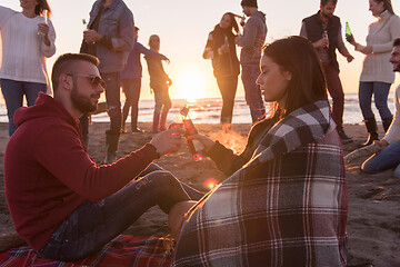 Image showing Couple enjoying with friends at sunset on the beach