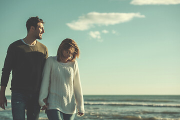 Image showing Loving young couple on a beach at autumn sunny day