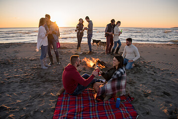 Image showing Couple enjoying with friends at sunset on the beach