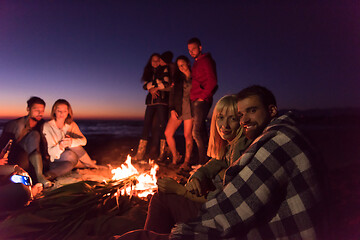 Image showing Couple enjoying with friends at sunset on the beach