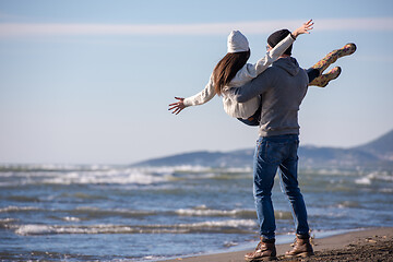 Image showing Loving young couple on a beach at autumn sunny day