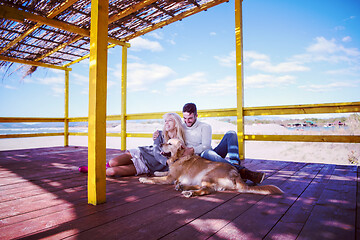 Image showing Couple with dog enjoying time on beach