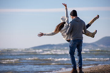 Image showing Loving young couple on a beach at autumn sunny day