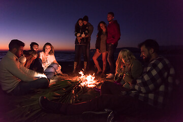 Image showing Couple enjoying with friends at sunset on the beach