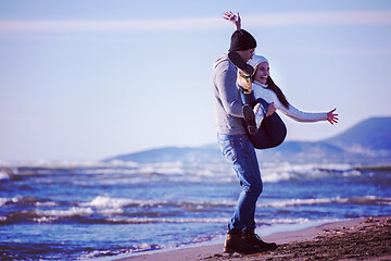 Image showing Loving young couple on a beach at autumn sunny day