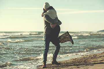 Image showing Loving young couple on a beach at autumn sunny day