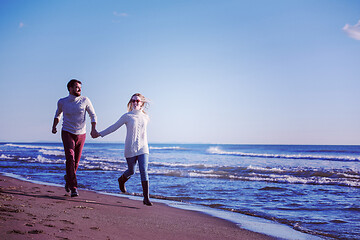 Image showing Loving young couple on a beach at autumn sunny day