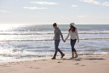 Image showing Loving young couple on a beach at autumn sunny day