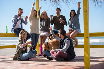 Image showing Group of friends having fun on autumn day at beach