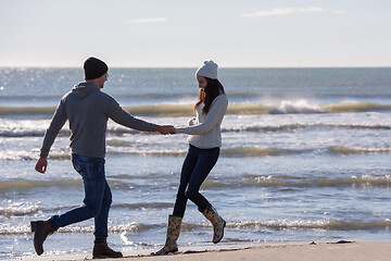 Image showing Loving young couple on a beach at autumn sunny day