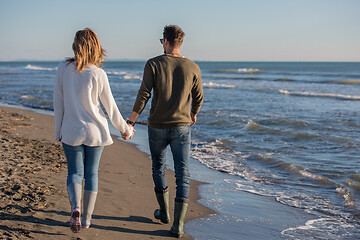 Image showing Loving young couple on a beach at autumn sunny day