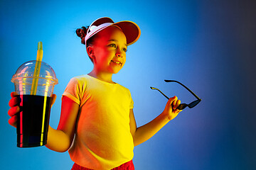 Image showing The happy teen girl standing and smiling against blue background.