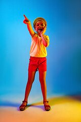 Image showing The happy teen girl standing and smiling against blue background.