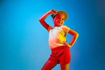 Image showing The happy teen girl standing and smiling against blue background.