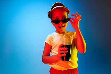 Image showing The happy teen girl standing and smiling against blue background.