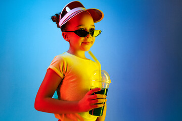 Image showing The happy teen girl standing and smiling against blue background.