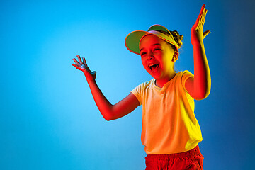 Image showing The happy teen girl standing and smiling against blue background.